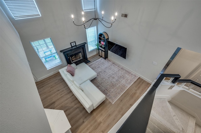 8909 White Pine Ln, Dallas, TX 75238 - living room with a chandelier, wood finished floors, baseboards, a towering ceiling, and a fireplace