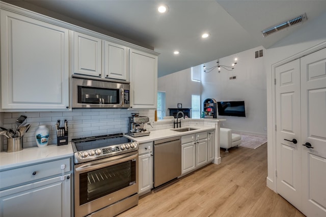 8909 White Pine Ln, Dallas, TX 75238 - kitchen with stainless steel appliances, a sink, open floor plan, decorative backsplash, and light wood-style floors