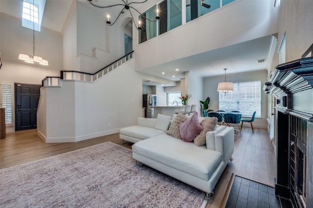 8909 White Pine Ln, Dallas, TX 75238 - living area with baseboards, a high ceiling, a chandelier, wood finished floors, and crown molding