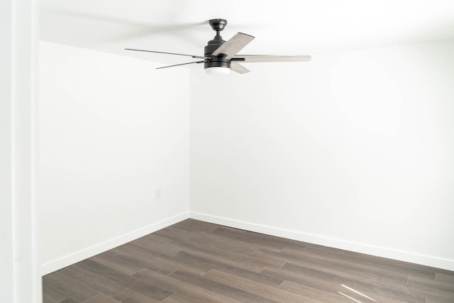 spare room featuring baseboards, dark wood finished floors, and ceiling fan