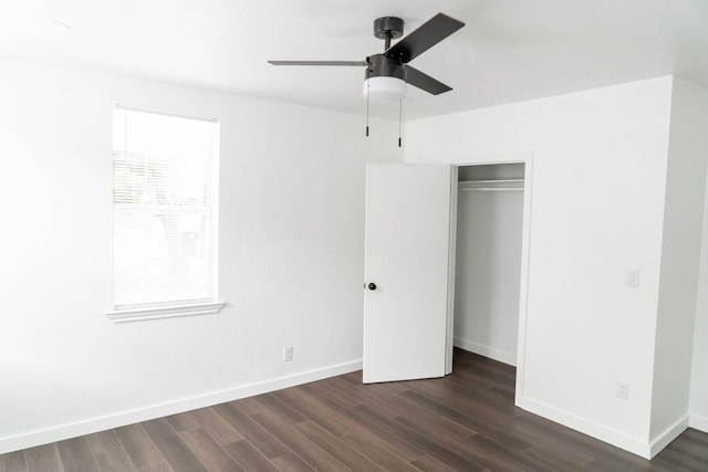 unfurnished bedroom featuring baseboards, ceiling fan, a closet, and dark wood-style flooring
