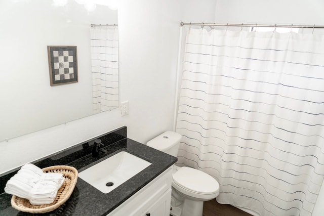 bathroom featuring toilet, a shower with curtain, and vanity