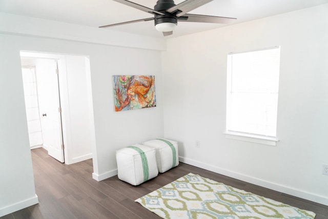 interior space featuring a ceiling fan, baseboards, and wood finished floors