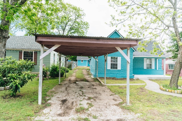 exterior space featuring a storage shed, aphalt driveway, and a carport
