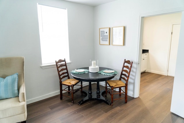 dining area featuring baseboards and dark wood-style floors