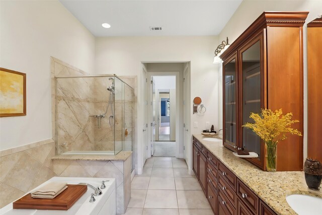 bathroom with tile patterned flooring, double vanity, visible vents, a garden tub, and a stall shower