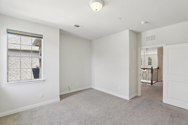 carpeted spare room with baseboards and visible vents