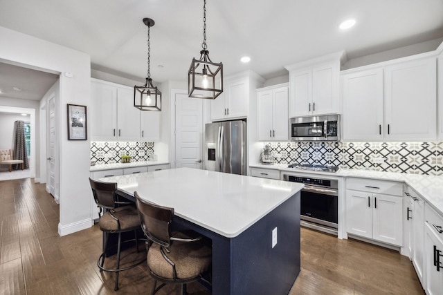 9408 Lamar St Unit D, Rowlett, TX 75089 - kitchen with appliances with stainless steel finishes, light countertops, backsplash, a center island, and white cabinetry