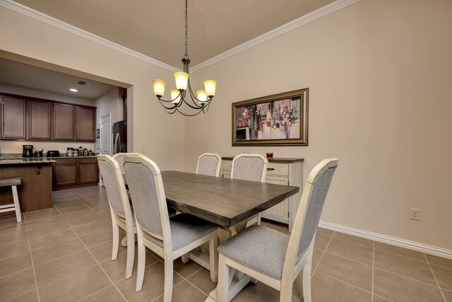 dining area featuring crown molding, baseboards, an inviting chandelier, and light tile patterned floors