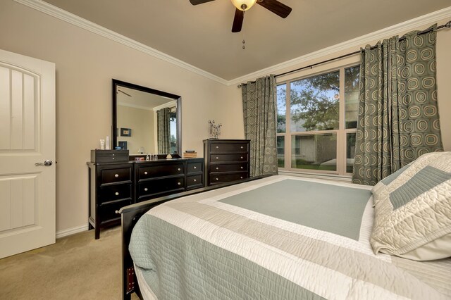 carpeted bedroom with baseboards, ornamental molding, and ceiling fan