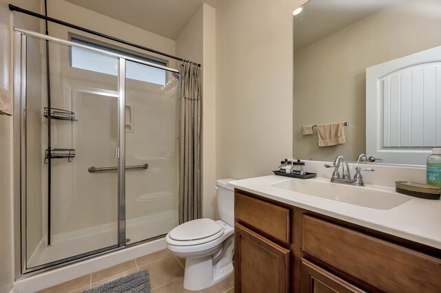 bathroom featuring vanity, tile patterned flooring, a shower stall, and toilet