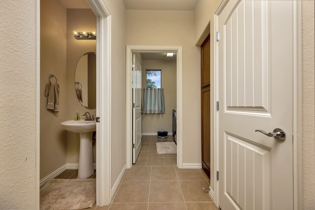 bathroom with baseboards, tile patterned floors, and a sink