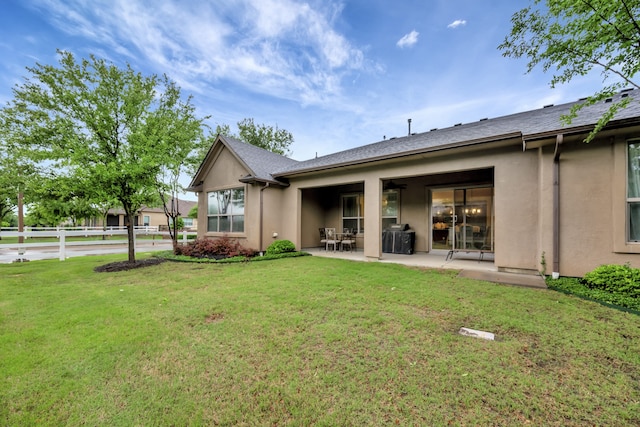 12521 Gritstone Dr, Denton, TX 76207 - rear view of house with stucco siding, a patio area, and a yard