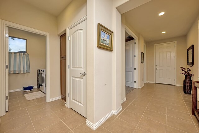 corridor with washing machine and clothes dryer, light tile patterned flooring, baseboards, and recessed lighting