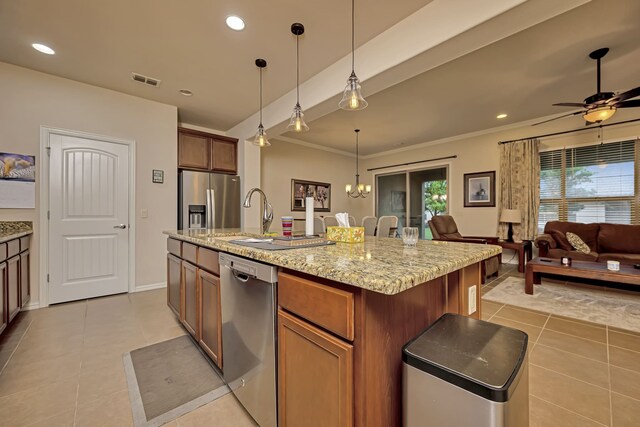 kitchen with appliances with stainless steel finishes, hanging light fixtures, a sink, light tile patterned floors, and open floor plan