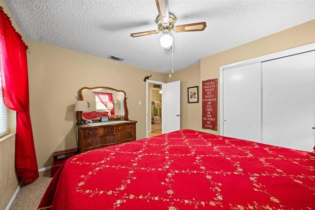 bedroom featuring visible vents, a ceiling fan, a closet, a textured ceiling, and carpet flooring