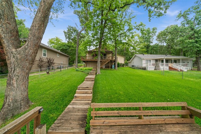view of yard featuring a wooden deck, fence private yard, and stairway
