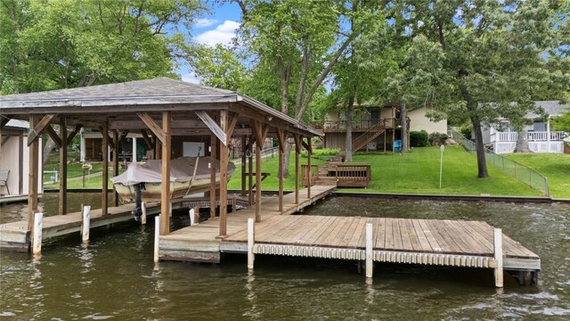 dock area featuring a water view, a yard, boat lift, and stairway