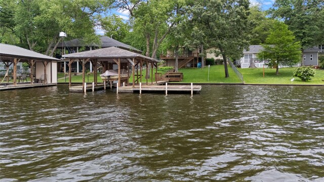 dock area featuring a lawn and a water view