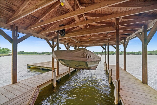 dock area featuring boat lift and a water view