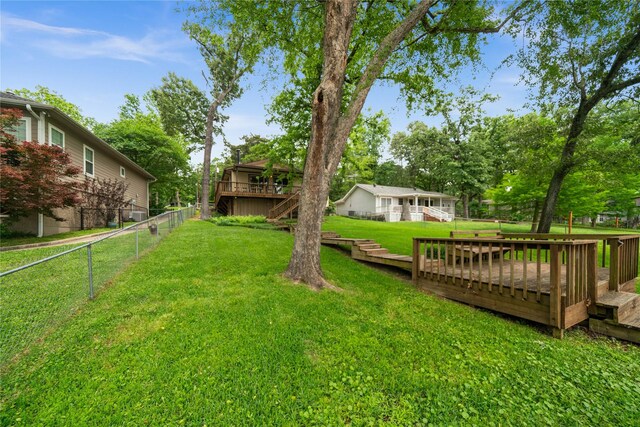 view of yard featuring a fenced backyard, a wooden deck, and stairs