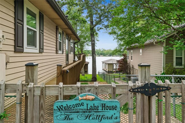 view of side of home featuring a water view and fence
