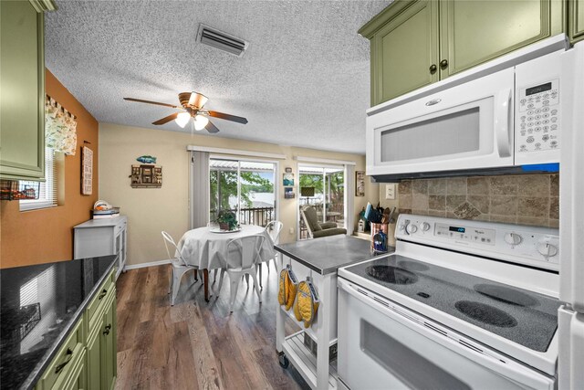 kitchen with white appliances, dark wood finished floors, a ceiling fan, visible vents, and green cabinets