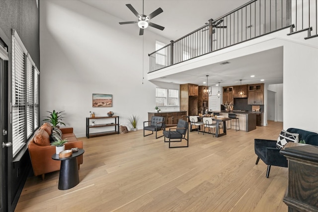 3805 Bluestem Blvd, Denton, TX 76226 - living room with a high ceiling, a ceiling fan, light wood-style floors, and recessed lighting