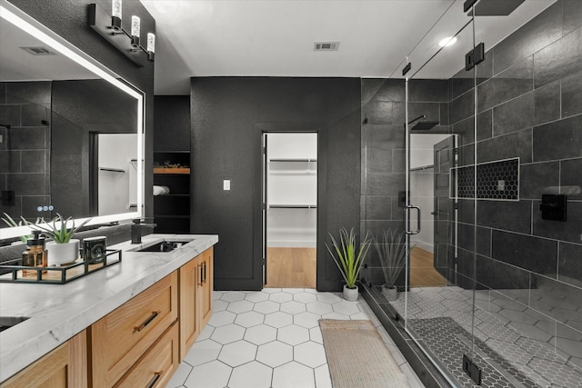 3805 Bluestem Blvd, Denton, TX 76226 - bathroom featuring double vanity, a shower stall, tile patterned flooring, and a walk in closet