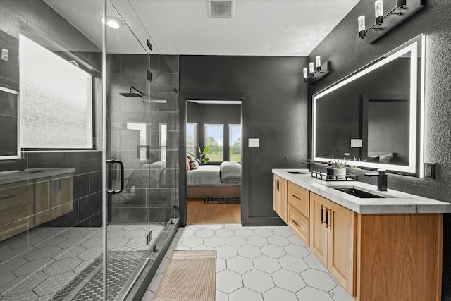 3805 Bluestem Blvd, Denton, TX 76226 - bathroom featuring tile patterned floors, double vanity, a shower stall, a textured wall, and connected bathroom