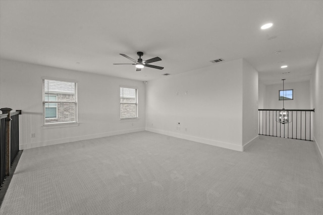 unfurnished room featuring visible vents, a ceiling fan, baseboards, and light carpet