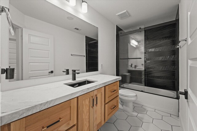 full bath with toilet, visible vents, combined bath / shower with glass door, and vanity