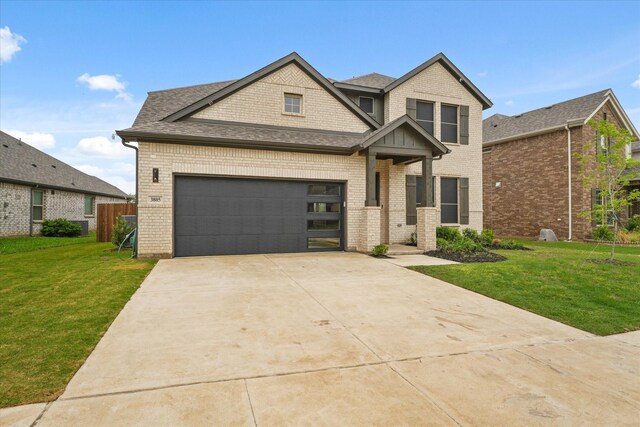 traditional-style house with fence, a shingled roof, brick siding, a front yard, and driveway