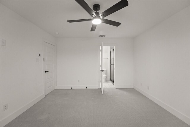 unfurnished bedroom featuring baseboards, ensuite bathroom, light colored carpet, and visible vents