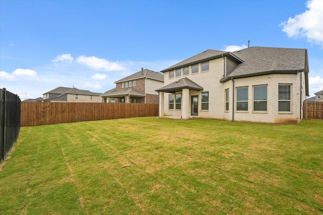 3805 Bluestem Blvd, Denton, TX 76226 - rear view of house featuring a fenced backyard, brick siding, and roof with shingles