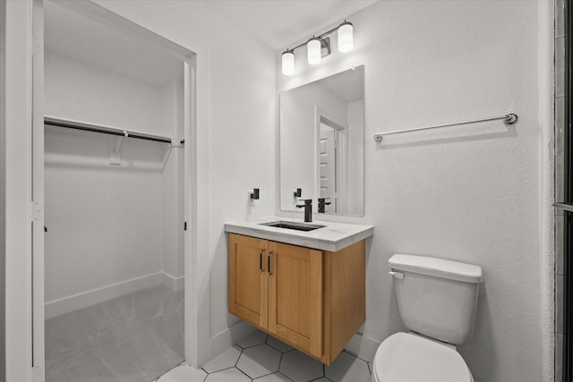 full bath featuring vanity, tile patterned flooring, a spacious closet, and toilet