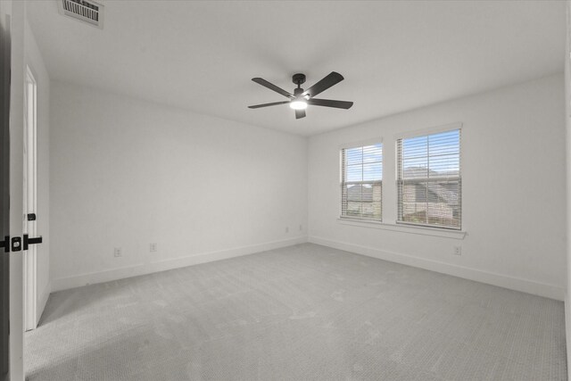 empty room with baseboards, ceiling fan, carpet flooring, and visible vents
