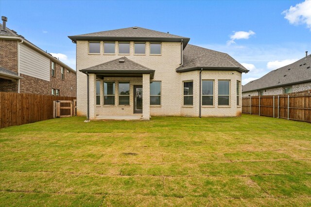 back of house featuring brick siding, a shingled roof, a fenced backyard, and a patio area