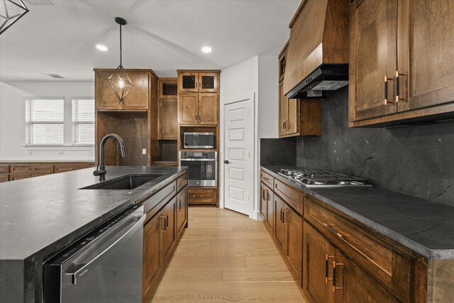 kitchen with custom range hood, a sink, dark countertops, and stainless steel appliances