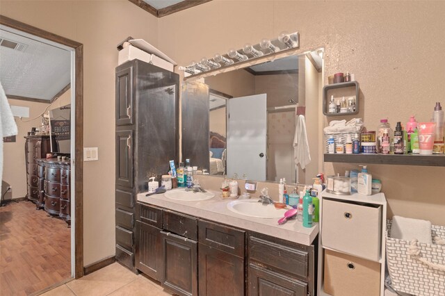 bathroom featuring a sink, tile patterned floors, double vanity, and visible vents