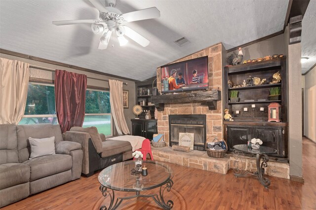 living room featuring a ceiling fan, visible vents, a fireplace, wood finished floors, and lofted ceiling