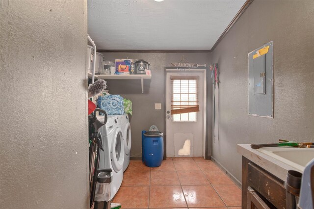 laundry area featuring a textured wall, laundry area, ornamental molding, washing machine and dryer, and electric panel