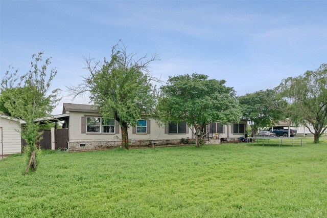 back of house featuring a yard, crawl space, and fence