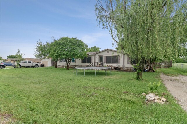 view of yard with a trampoline and fence
