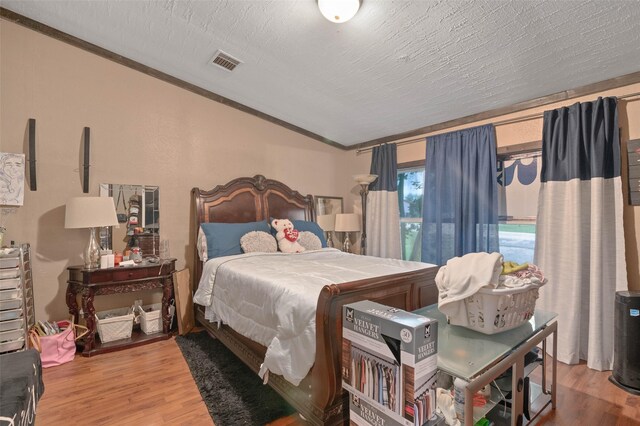 bedroom with lofted ceiling, wood finished floors, and visible vents
