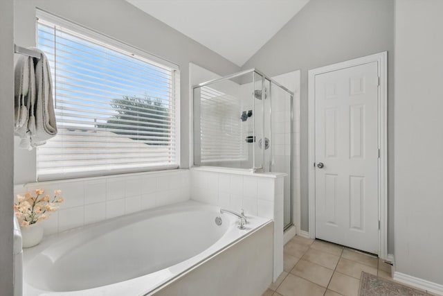 bathroom with tile patterned floors, a stall shower, a garden tub, and lofted ceiling