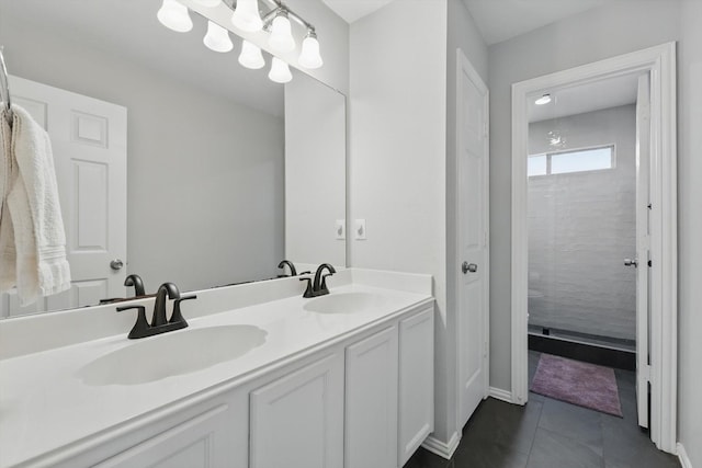 full bathroom with double vanity, baseboards, a sink, and tile patterned flooring