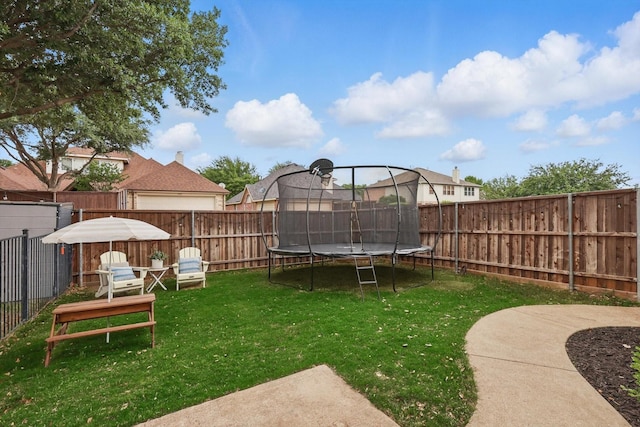 view of yard with a fenced backyard and a trampoline