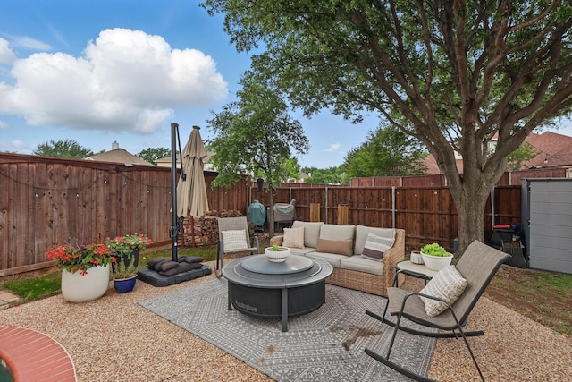 view of patio / terrace with a fenced backyard and an outdoor living space with a fire pit