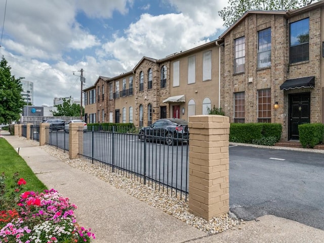 3817 Rawlins St Unit 103, Dallas, TX 75219 - view of front facade featuring fence and brick siding